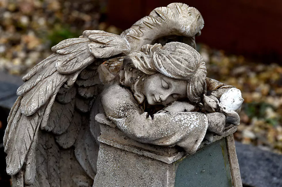 Engelsfigur aus Stein mit herbstlichem Hintergrund